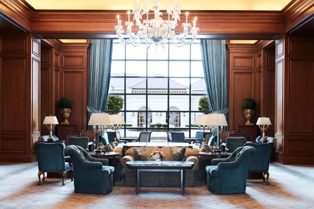Comfortable couches and seating sit before a large window opening up to the Grand America courtyard.