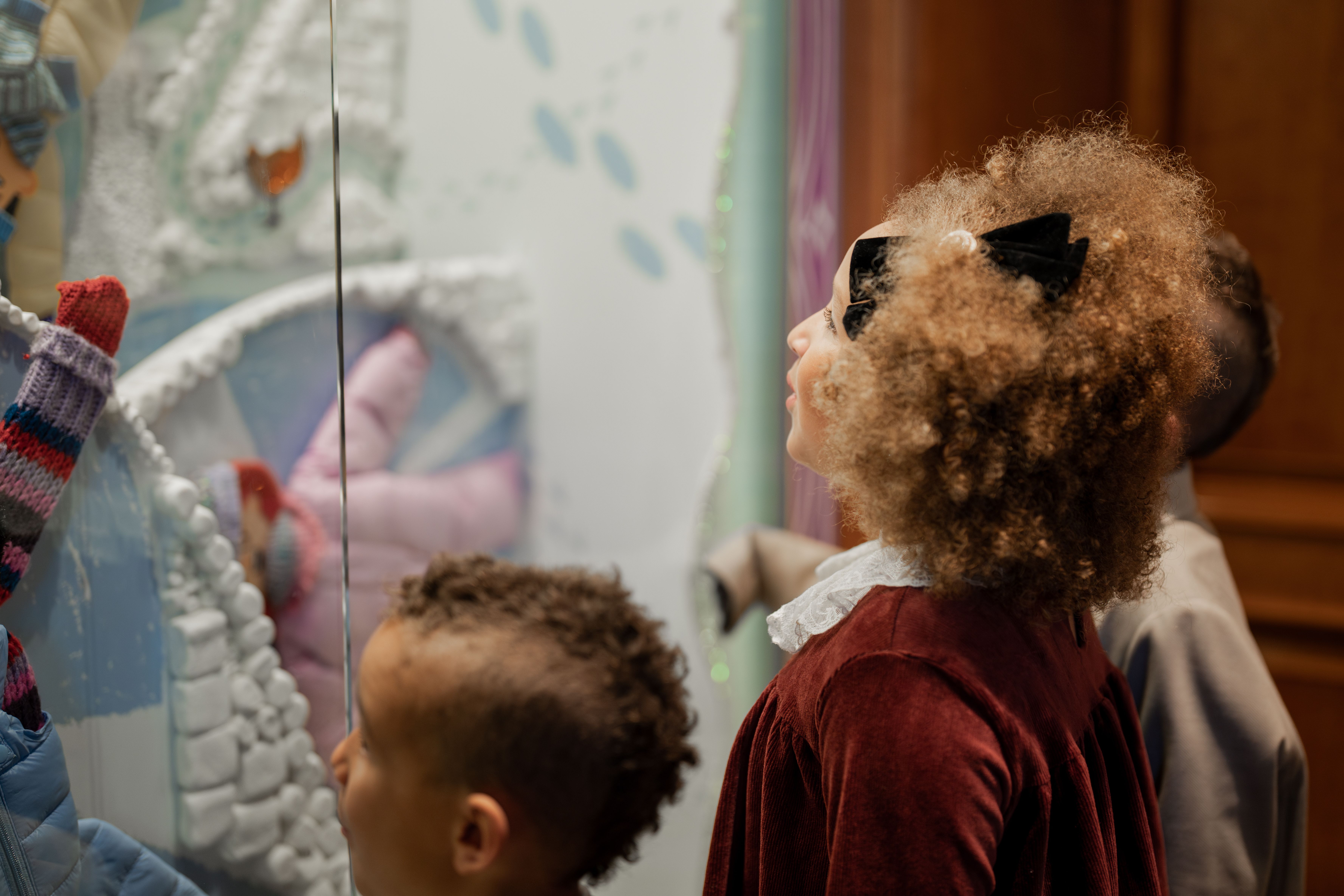 Children looking at a holiday window display