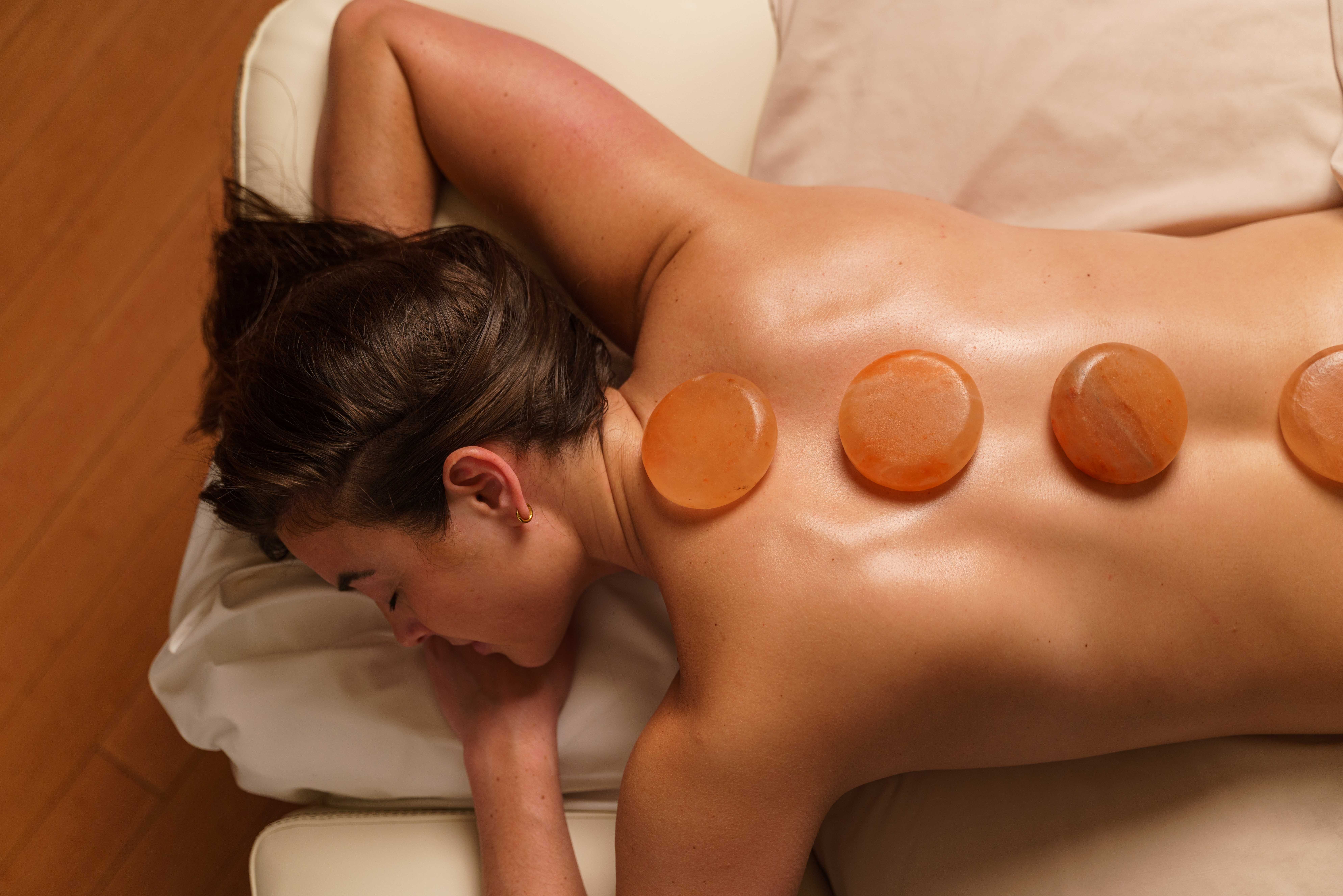 Woman with hot stones on her back during a hot stone massage