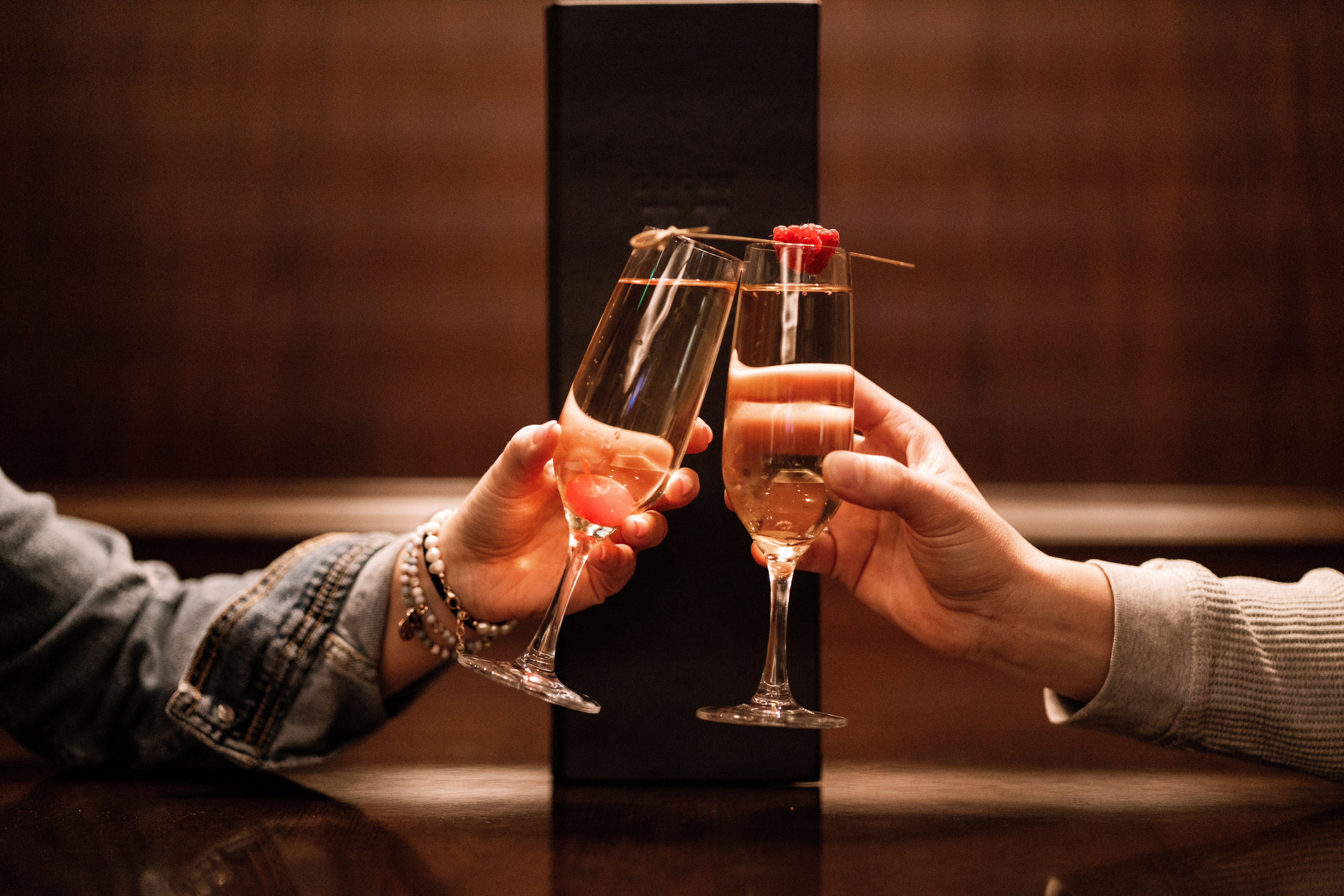 A couple doing a cheers with two glasses of champagne