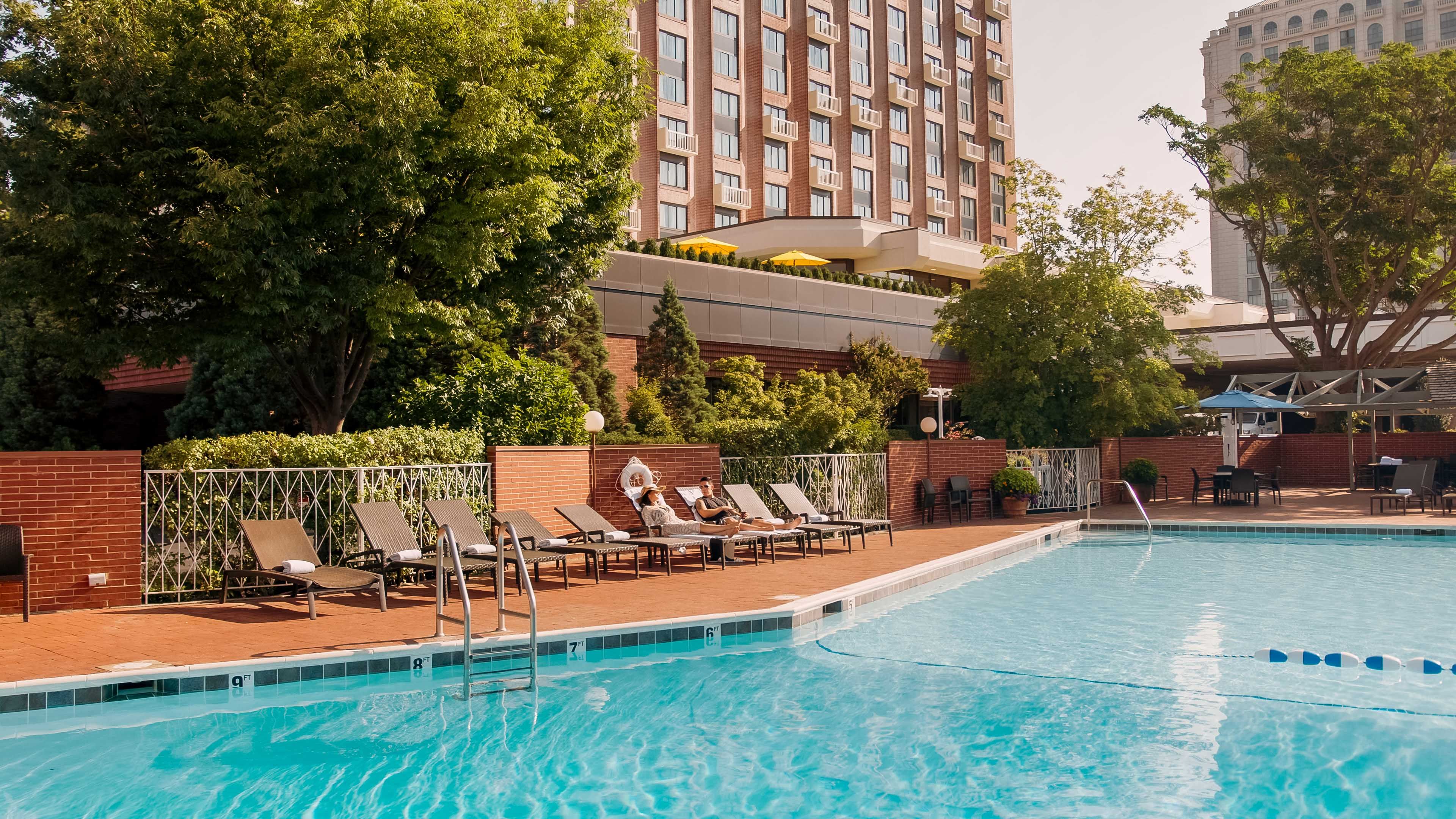 Couple sitting in lounge chairs at the outdoor pool
